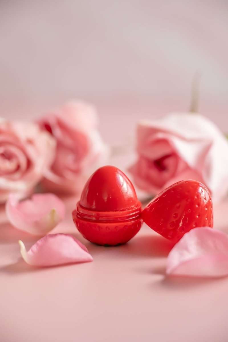 Red strawberry lip butter balm domes with rose petals around them