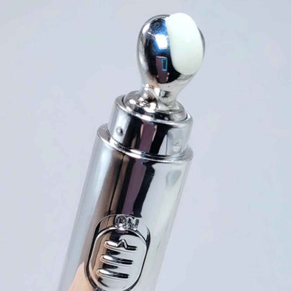 Eye cream roller applicator close-up with white cream pad on chrome cap