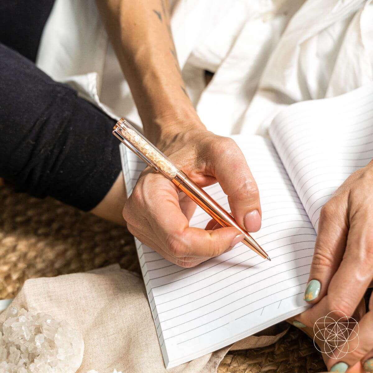 Manifestation pen writing with a copper glitter pen and lined notebook pages