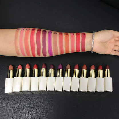 Wrist and row of matte lipsticks with many swatches in red, plum, and nude tones