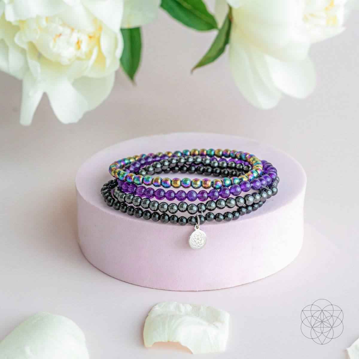 Beaded wrap bracelet set with purple and black beads plus a round silver charm