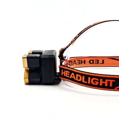 Orange LED headlamp with black housing and strap, angled side view