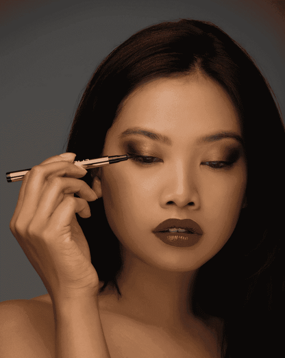 Liquid eyeliner pen with fine precision tip, applied along the upper lash line
