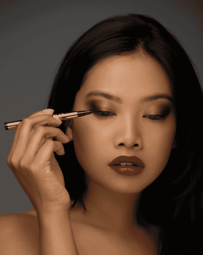 Liquid eyeliner pen with fine precision tip, applied along the upper lash line