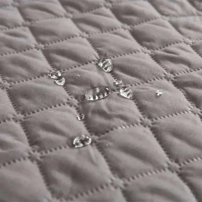 Pet bed cover, gray quilted fabric with visible snap buttons close-up.