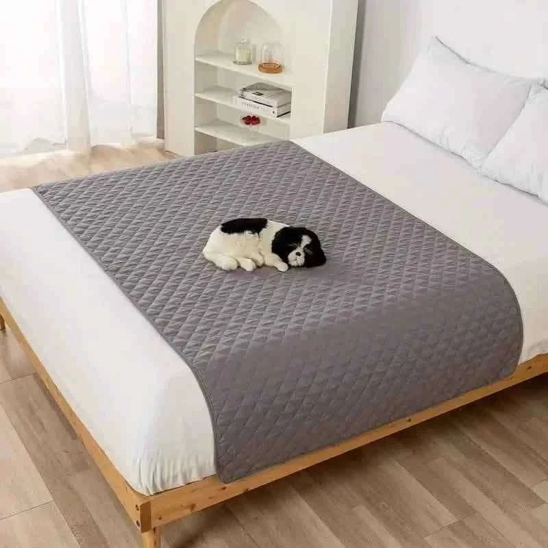 Pet bed cover, light gray quilted cover on furniture with a small dog.