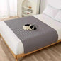Pet bed cover, light gray quilted cover on furniture with a small dog.