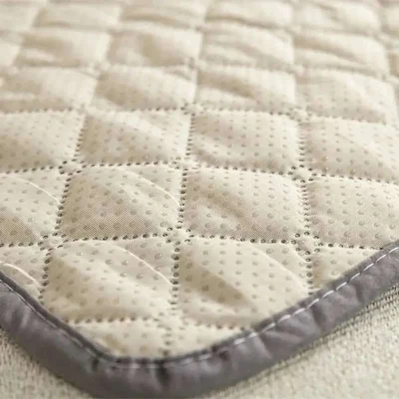 Pet bed cover, cream textured quilt with gray edge trim close-up.