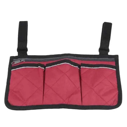 Red wheelchair armrest organizer bag with three front pockets and black edge trim.