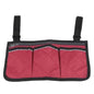 Red wheelchair armrest organizer bag with three front pockets and black edge trim.