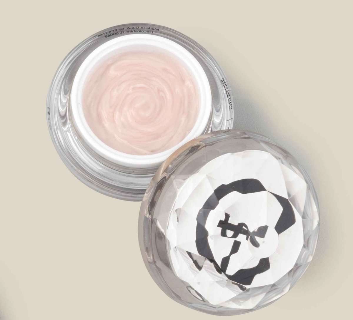 Pale pink cream in clear glass jar, wrinkle-smoothing face cream