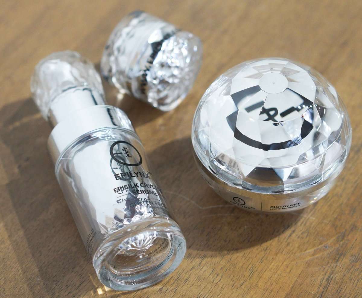 EpiLynx crystal-style skincare bottles and jar on a wooden surface