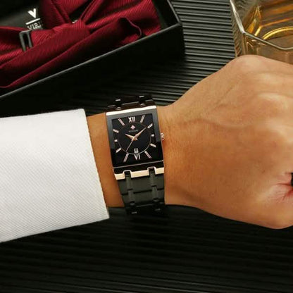 Men’s square date watch on wrist with black dial and black metal link band